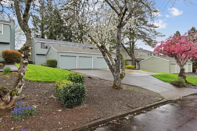 view of front of home featuring an attached garage, driveway, and a front lawn