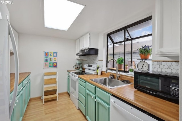 kitchen featuring a sink, white appliances, decorative backsplash, under cabinet range hood, and green cabinets