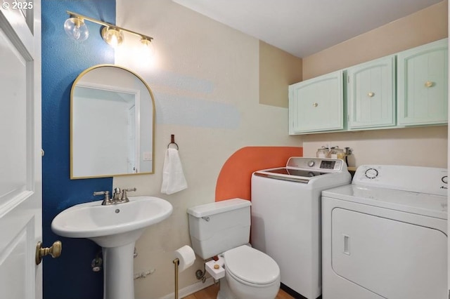 bathroom featuring a sink, toilet, and independent washer and dryer