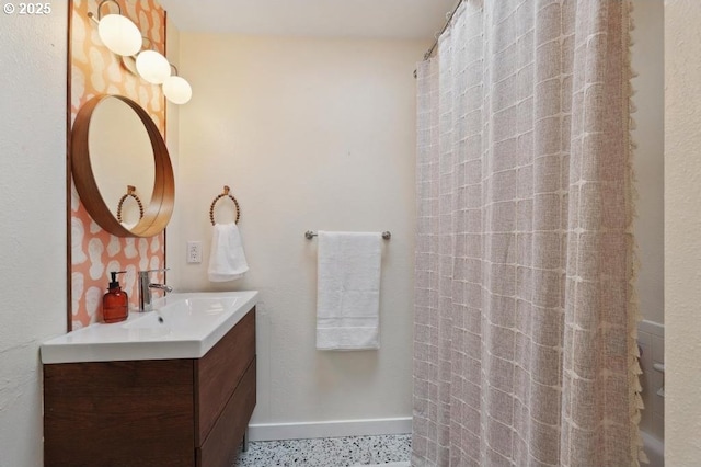 full bathroom featuring vanity, baseboards, a shower with curtain, and speckled floor