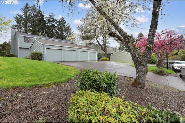 exterior space with a chimney, a yard, and driveway