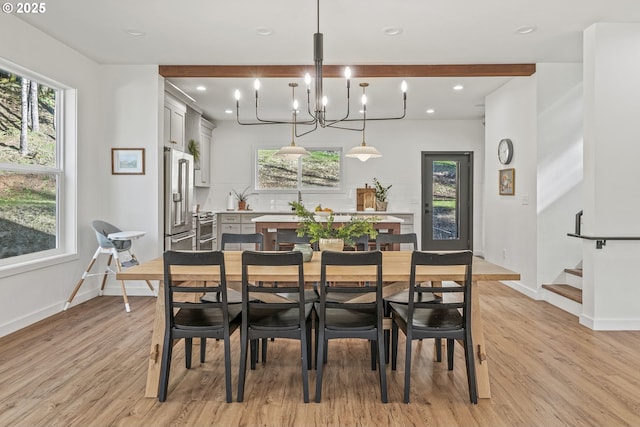 dining space with light wood-type flooring, baseboards, a healthy amount of sunlight, and stairs