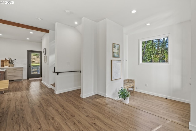 interior space with beam ceiling, recessed lighting, baseboards, and wood finished floors