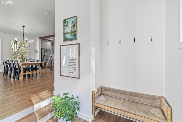 mudroom featuring light wood finished floors, baseboards, and an inviting chandelier