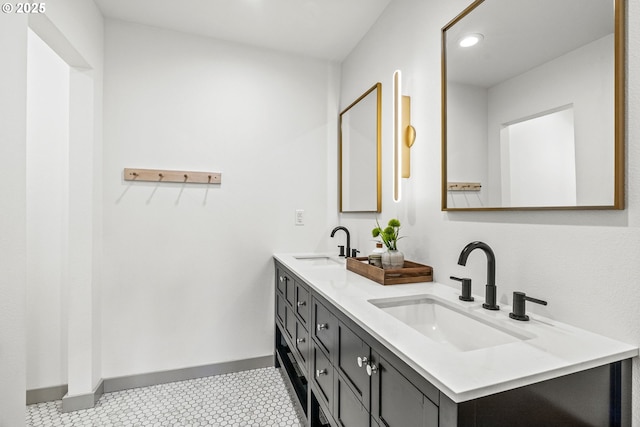 bathroom featuring double vanity, recessed lighting, baseboards, and a sink