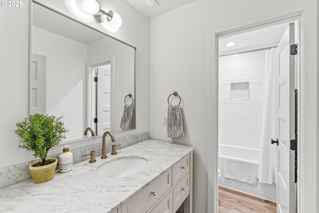 full bathroom with vanity, shower / bathtub combination with curtain, and wood finished floors