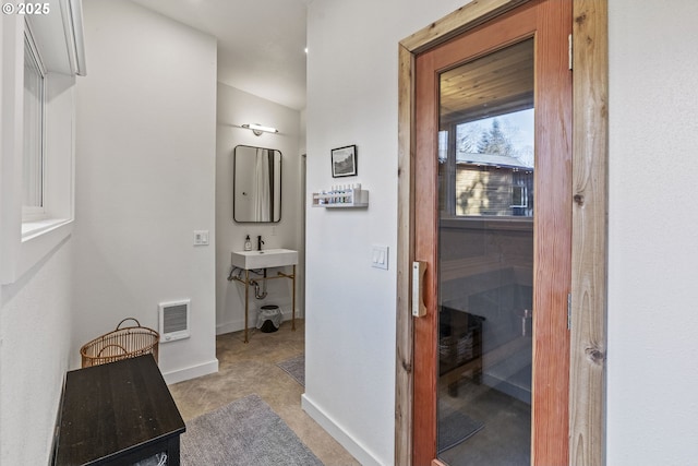 hallway featuring a sauna, visible vents, baseboards, and a sink