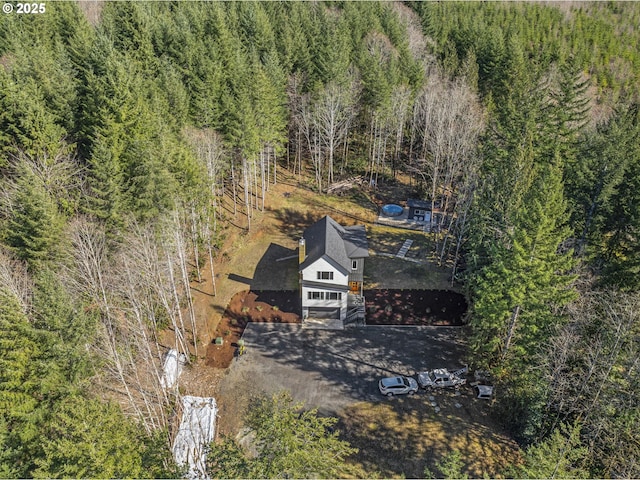 drone / aerial view featuring a wooded view