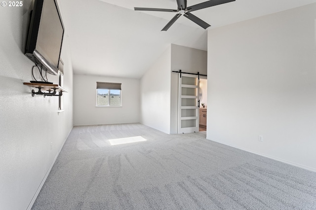17006 SE 6th St, Vancouver, WA 98684 - unfurnished living room with a barn door, a ceiling fan, carpet floors, vaulted ceiling, and baseboards