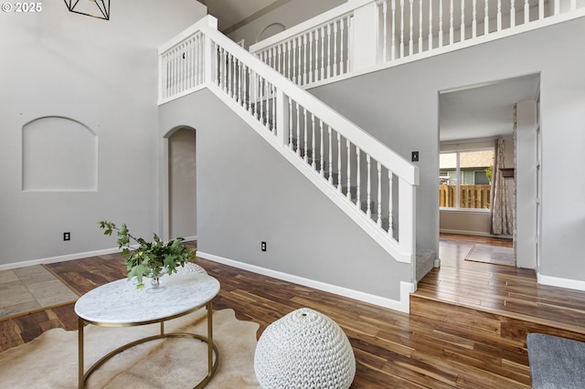 17006 SE 6th St, Vancouver, WA 98684 - living room featuring arched walkways, a high ceiling, wood finished floors, baseboards, and stairway