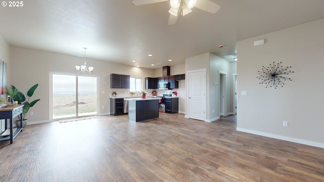 kitchen featuring stainless steel microwave, open floor plan, electric stove, and a center island