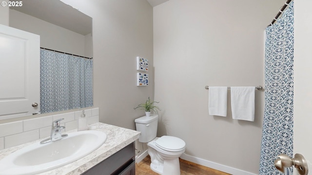 bathroom featuring toilet, vanity, and hardwood / wood-style flooring