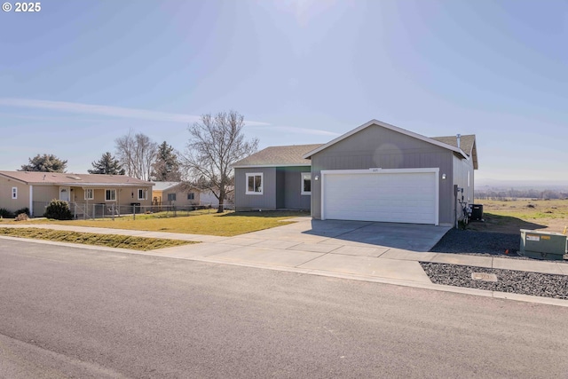 single story home with an attached garage, driveway, fence, and a front lawn