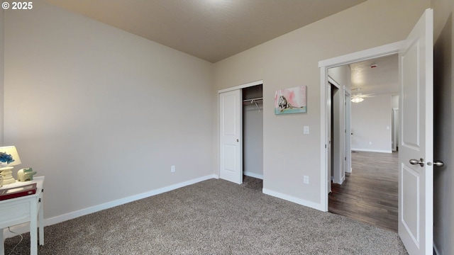 unfurnished bedroom with a closet and dark colored carpet