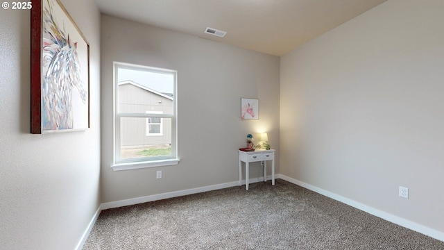 carpeted spare room with visible vents and baseboards