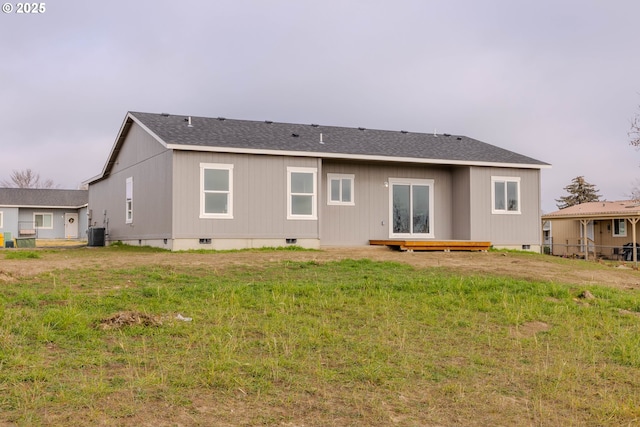 back of property with a yard and central air condition unit