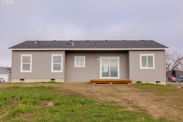 rear view of property featuring a lawn