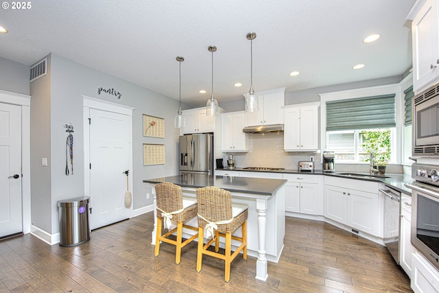 15928 Stables Pl, Oregon City, OR 97045 - kitchen featuring dark countertops, a sink, dark wood-style floors, stainless steel appliances, and white cabinetry