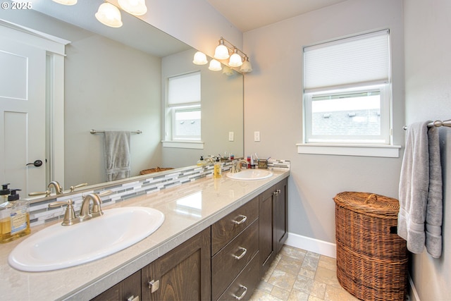 15928 Stables Pl, Oregon City, OR 97045 - bathroom featuring double vanity, baseboards, stone finish floor, and a sink