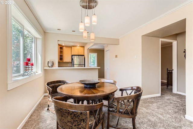 carpeted dining space with ornamental molding