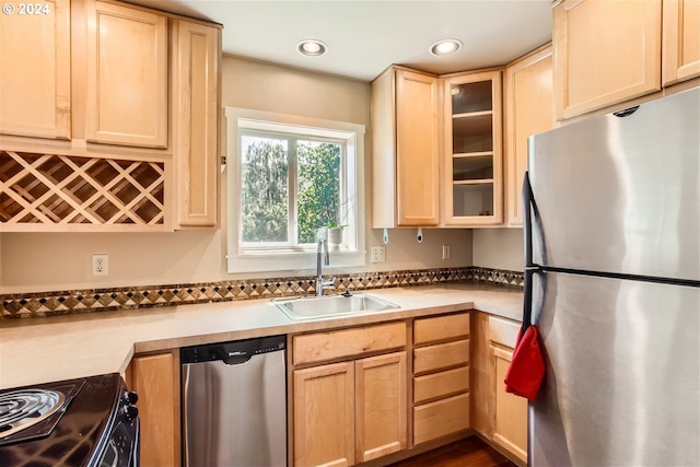 kitchen featuring light brown cabinets, stainless steel appliances, and sink