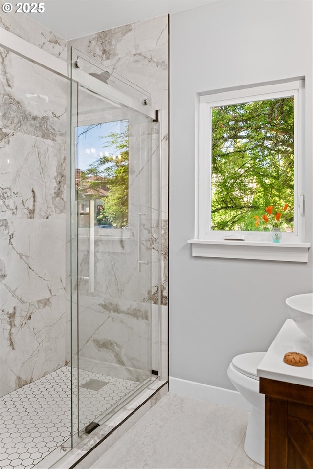 bathroom with a marble finish shower, baseboards, vanity, and toilet