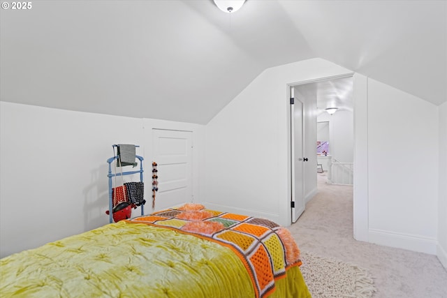bedroom featuring light colored carpet, baseboards, and vaulted ceiling