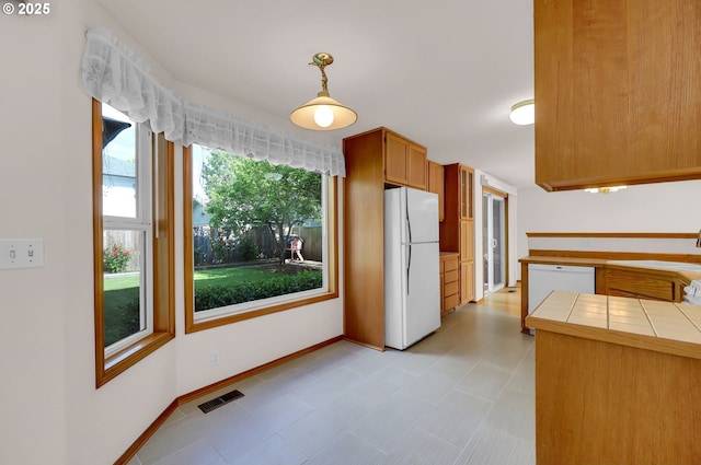 4095 Eddystone Pl, Eugene, OR 97404 - kitchen featuring white appliances, tile counters, a sink, hanging light fixtures, and baseboards