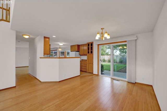 4095 Eddystone Pl, Eugene, OR 97404 - kitchen with a chandelier, brown cabinets, light wood-style floors, baseboards, and a peninsula