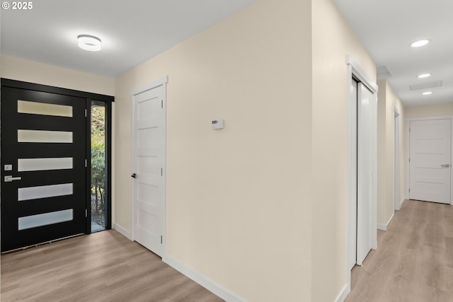 foyer entrance with light wood-style floors, recessed lighting, and baseboards