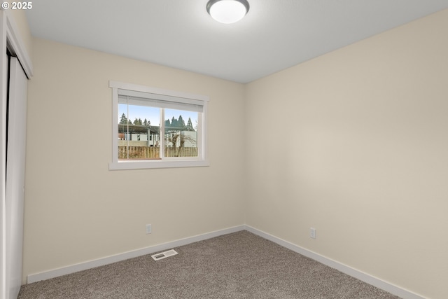 interior space with a closet, carpet flooring, visible vents, and baseboards