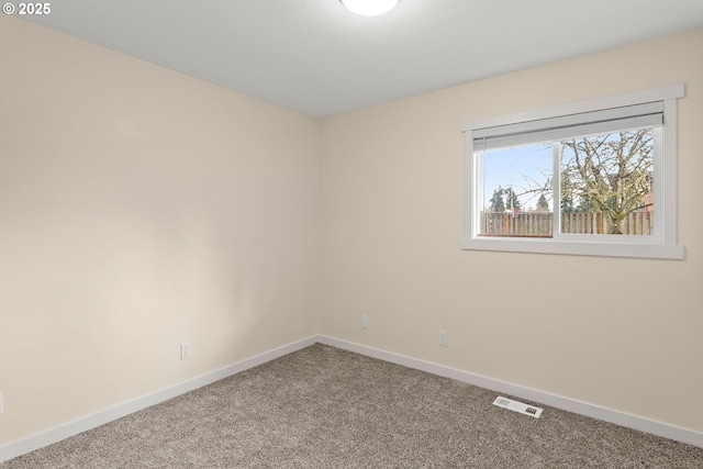 carpeted empty room featuring visible vents and baseboards