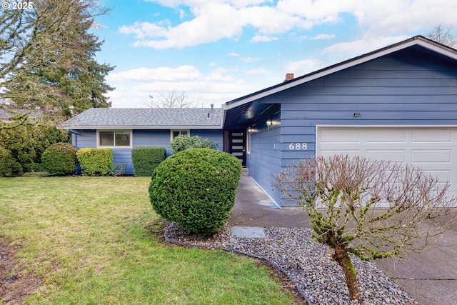 ranch-style house featuring an attached garage and a front yard