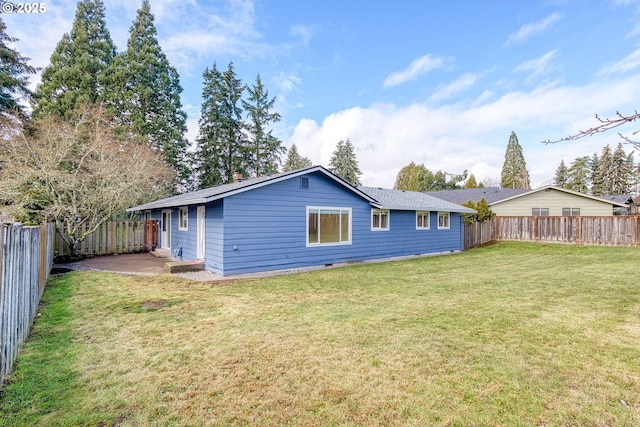 rear view of property featuring a patio, a lawn, and a fenced backyard