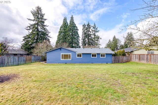 back of house with a fenced backyard and a lawn