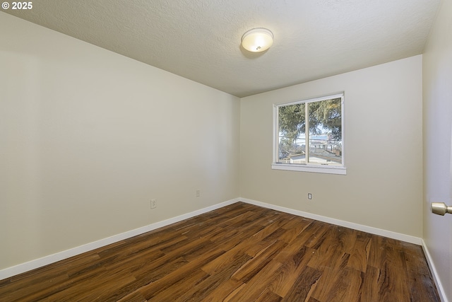 empty room featuring dark hardwood / wood-style flooring and a textured ceiling