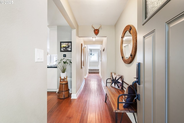 corridor featuring baseboards and wood finished floors