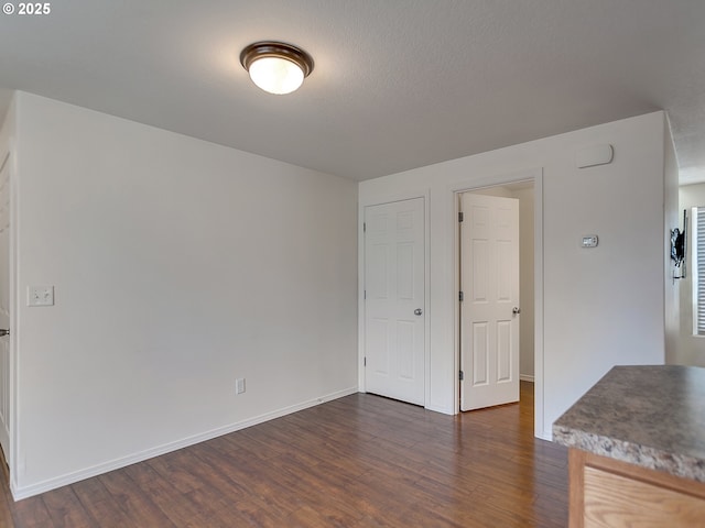 interior space featuring dark wood finished floors and baseboards