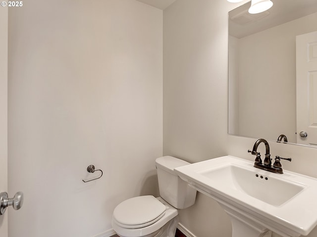 bathroom with a sink, baseboards, and toilet