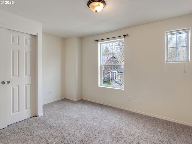 unfurnished room featuring baseboards and carpet