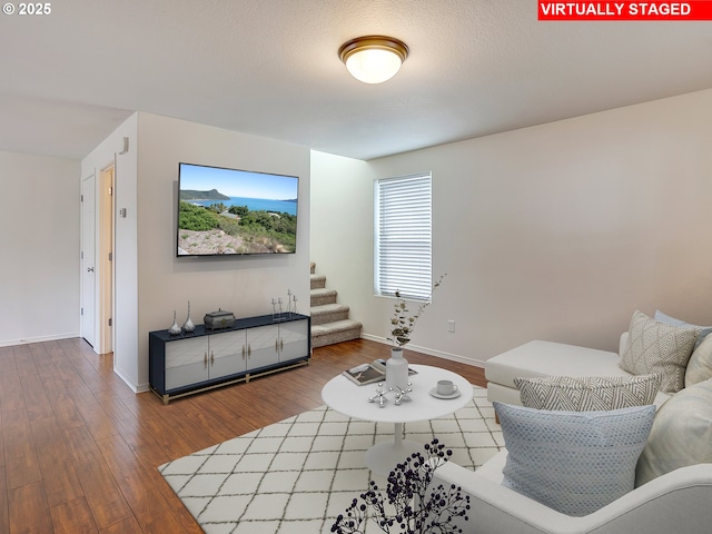 living area featuring stairway, baseboards, and wood finished floors