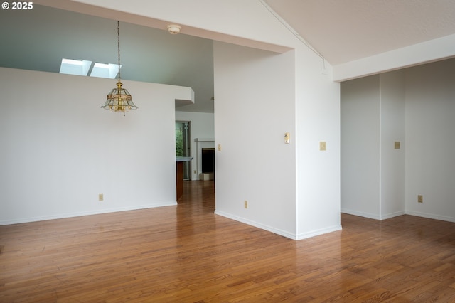 empty room featuring lofted ceiling and hardwood / wood-style floors