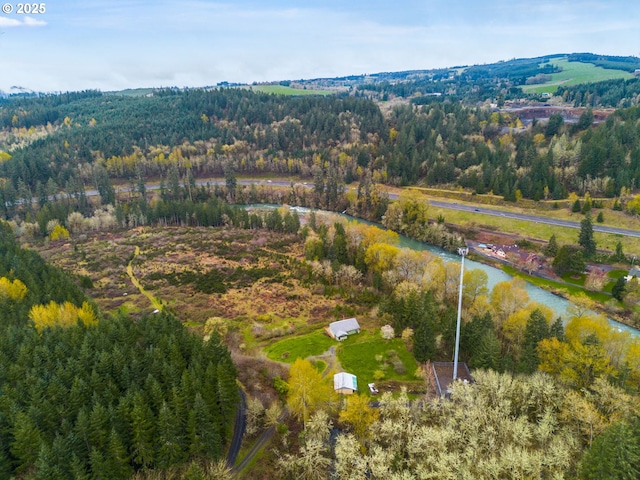 drone / aerial view featuring a water view and a forest view