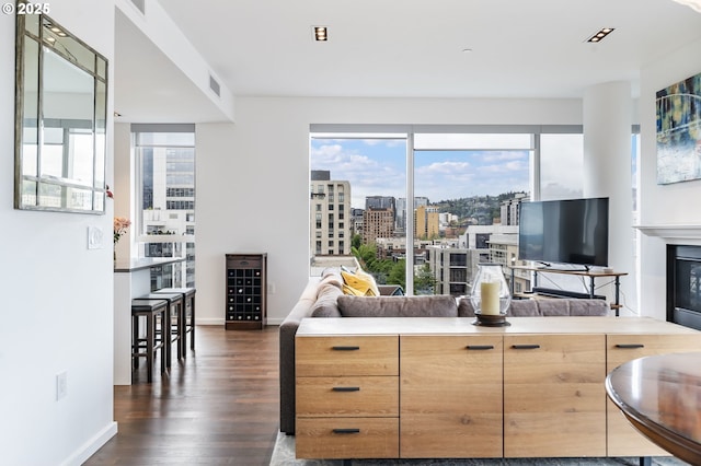1075 NW Northrup St Unit 814, Portland, OR 97209 - living area with a glass covered fireplace, baseboards, dark wood-style floors, and visible vents