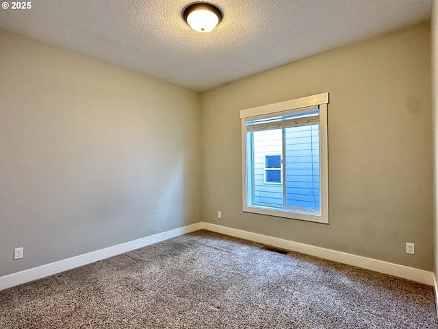 carpeted spare room featuring a textured ceiling