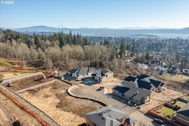 aerial view with a forest view, a mountain view, and a residential view