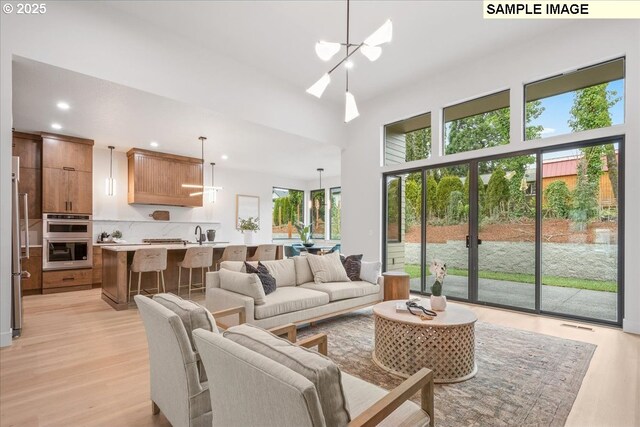 kitchen with a breakfast bar, light hardwood / wood-style flooring, a kitchen island, white cabinets, and wall chimney exhaust hood