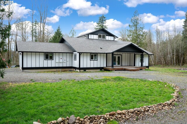 view of front of home featuring board and batten siding, a front yard, a shingled roof, and french doors