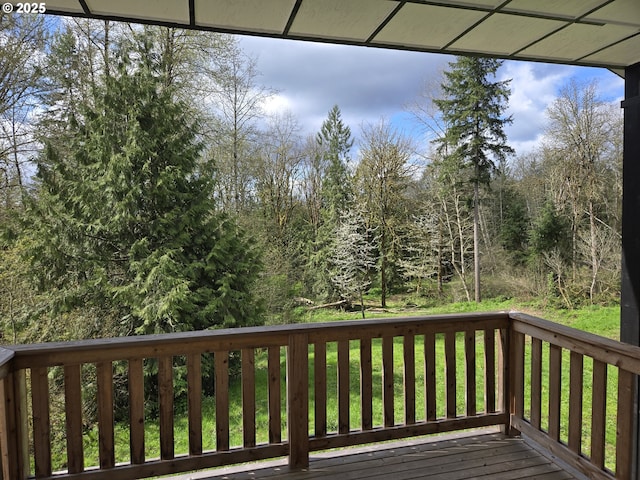 deck with a yard and a forest view
