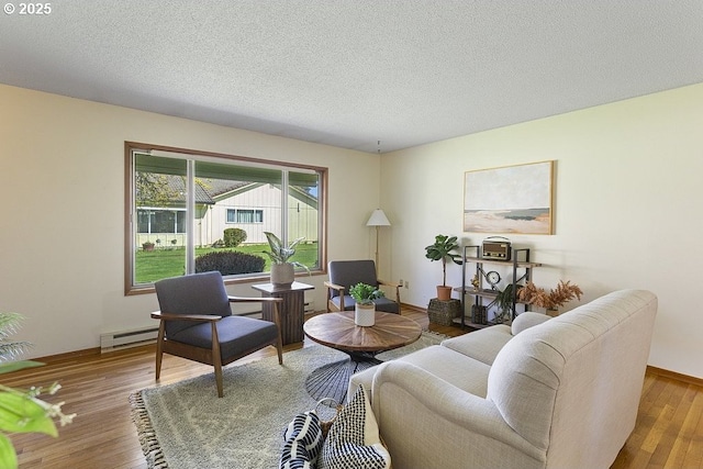 12395 SE Main St, Portland, OR 97233 - living room with a baseboard heating unit, wood finished floors, and a textured ceiling